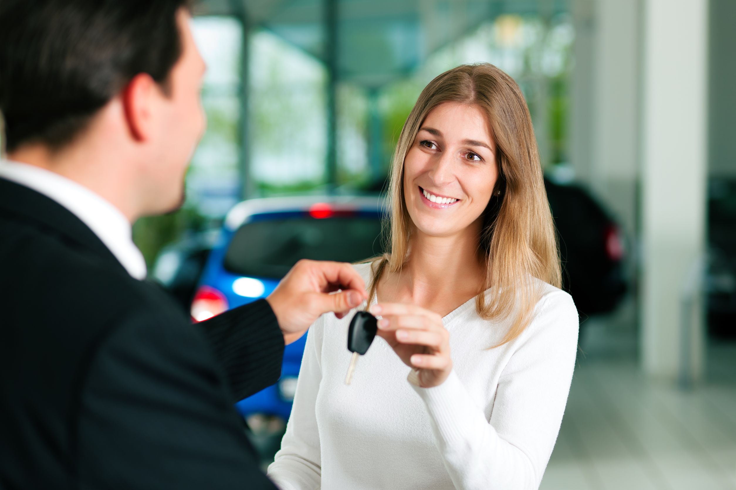 Salesman handing key to woman