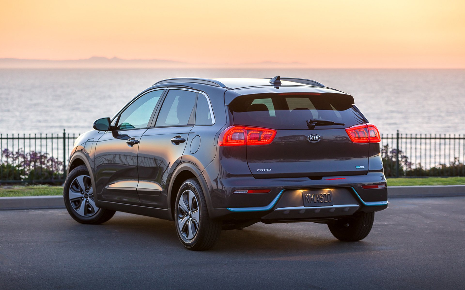 back of a kia niro by the water at sunset